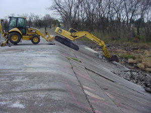 large Cat machinery breaking up the old spillway