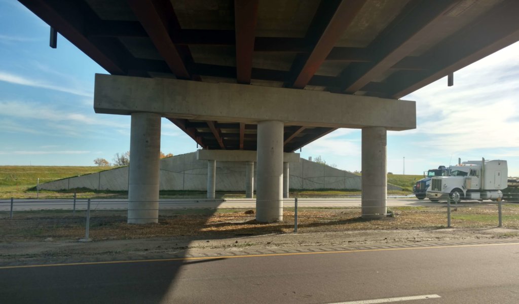 Underside of interstate bridge focusing on bridge piers and continuous welded plate girders.