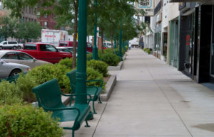 The downtown Clinton, Iowa streetscape uses planting beds, decorative lighting, and seating to create an inviting public space for pedestrians.