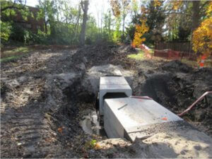 concrete storm sewer box being inserted in dirt
