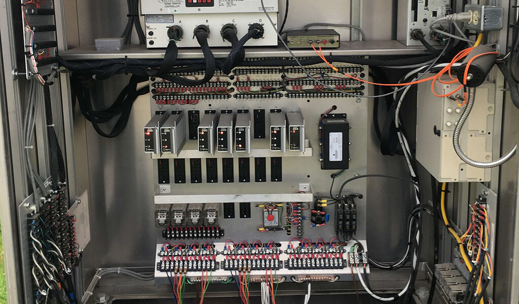 traffic light control panel filled with wire connections and switches