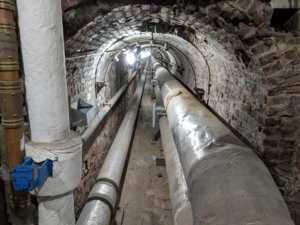 view inside old tunnel with pipes running through it