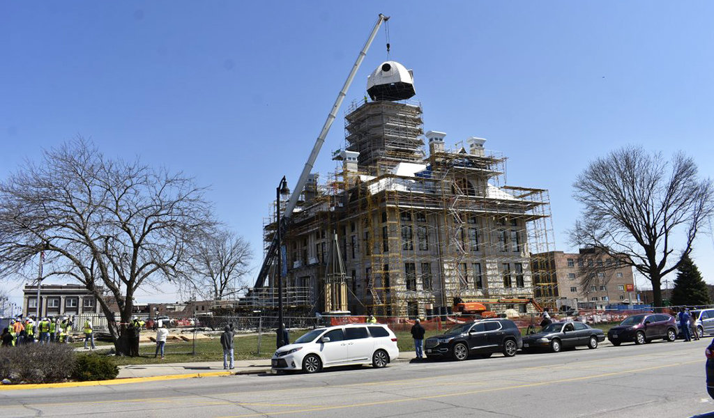 crane placing dome top back on courthouse building