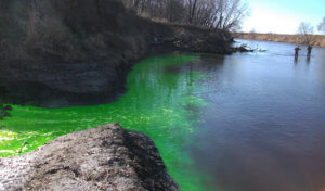 Green dye flows into river during dye testing