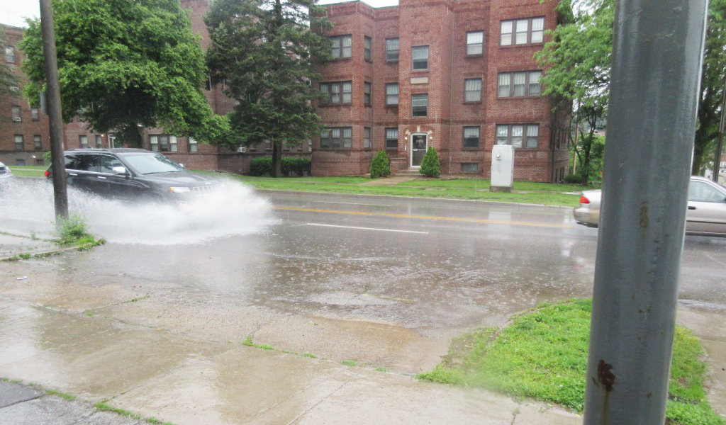 car sprays water while driving through a large puddle