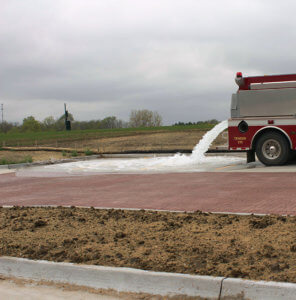 firetruck poring water onto permeable pavers