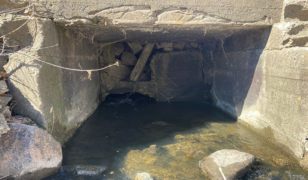 view inside penstock filled with loose stone and wood