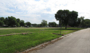 Flat grass land with trees primed for housing construction to begin