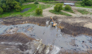 construction machinery creating low water crossing in a stream 