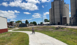 Child bikes a trail through a small town in Iowa