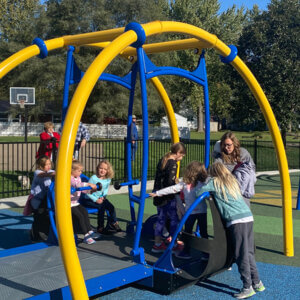 Kids playing on the ADA playground equipment at Pella's Kiwanis Park