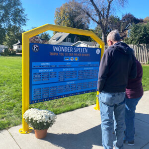 Two adults read a playground sign