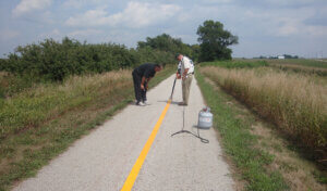 Two painters striping a trail