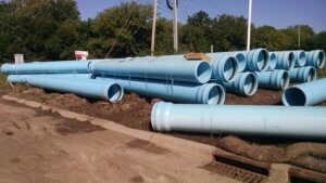 blue water pipes stacked along a roadway