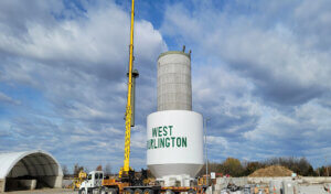 painted water tower top being raised into place