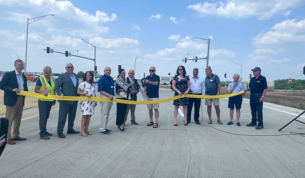 group of people attending a ribbon cutting for new roadway