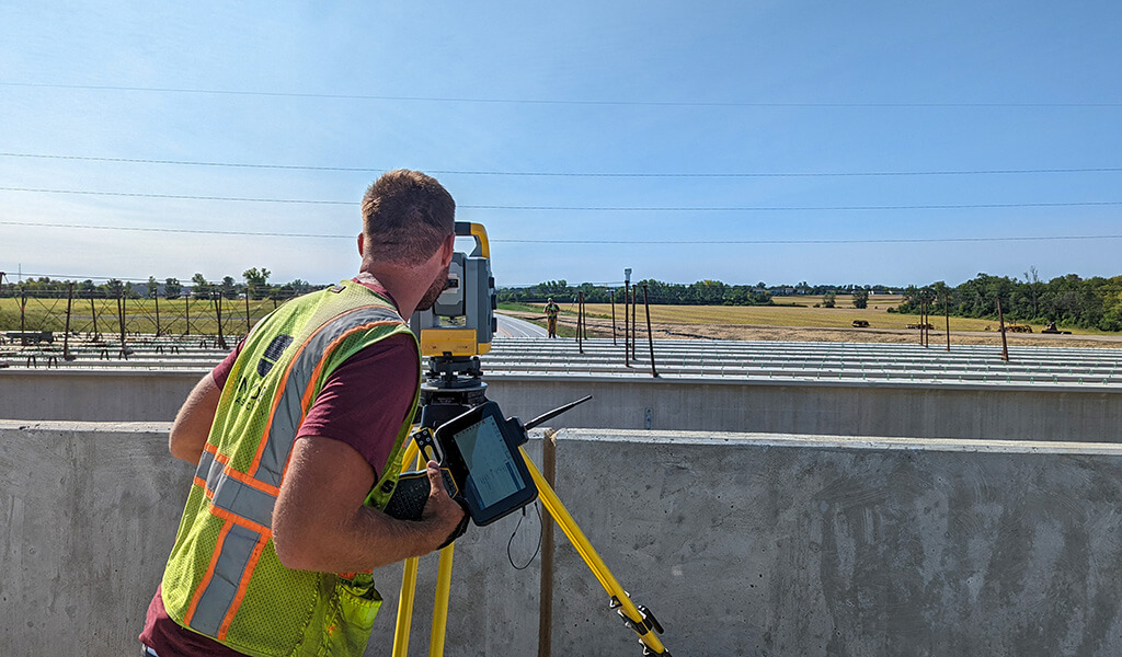 Snyder & Associates worker surveying roadway construction