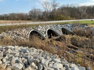 three stormwater culverts with water flowing