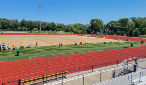 College community members helping lay down new sod on Iowa State's soccer field.