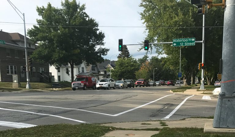 green light intersection at 12th street|red light intersection at Main street|street over stormwater outlet|view from middle of the street with double yellow line|