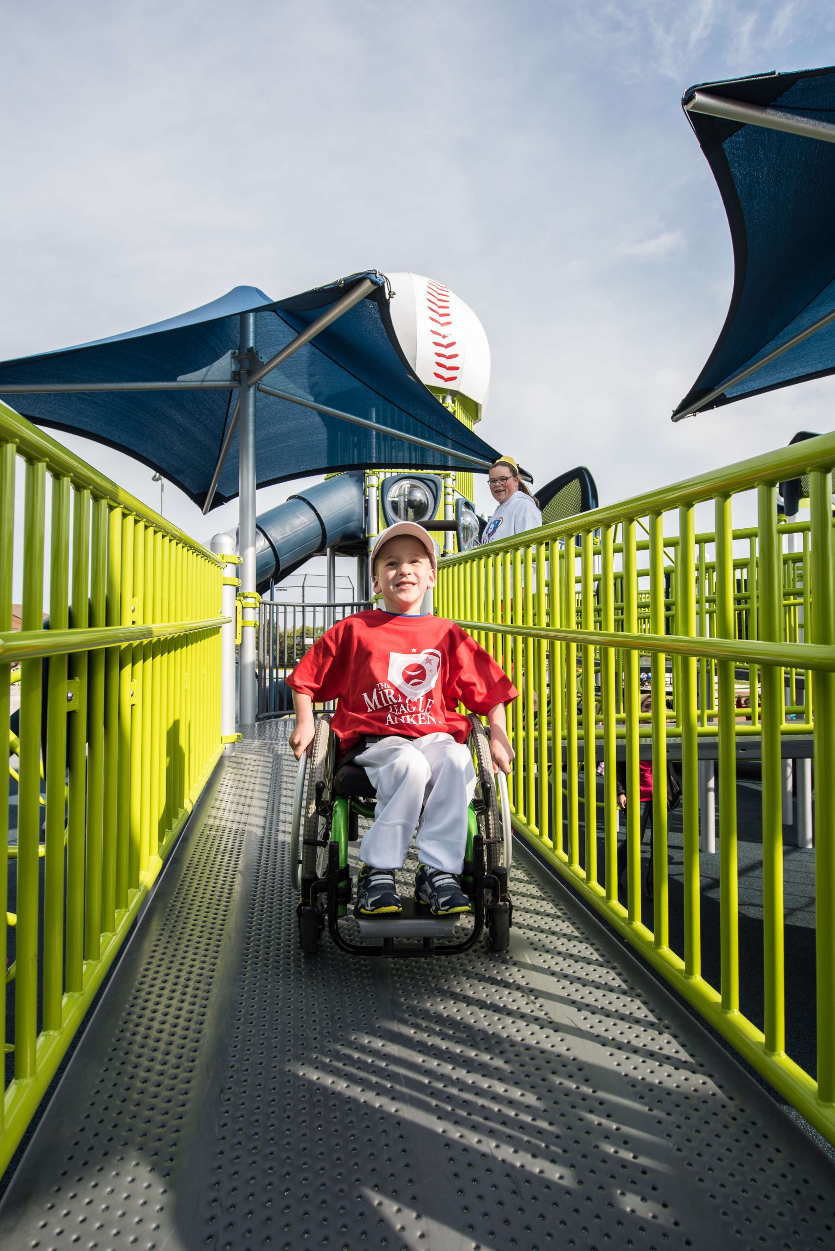 young boy in wheelchair playing on playground