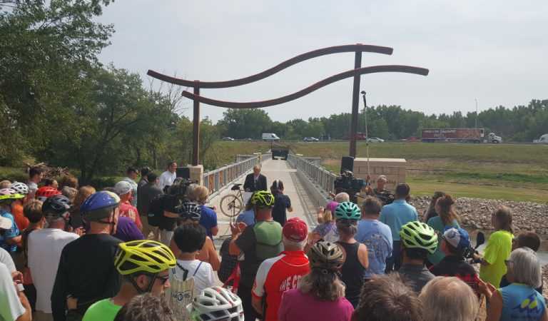|||||LED Bridge lighting|Couple walks across a lit up trail bridge at night||Night time bridge lighting