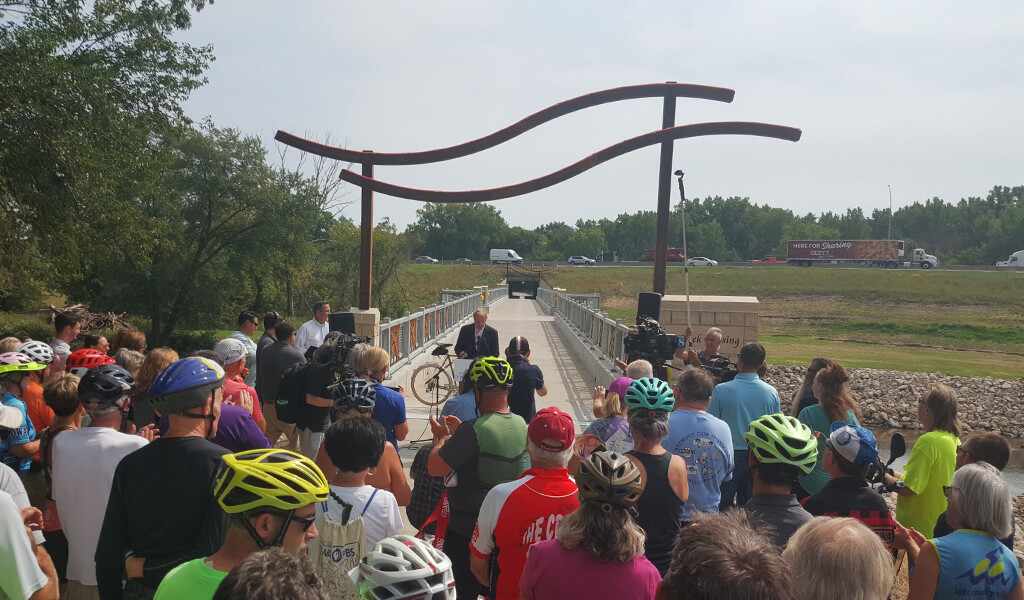 |||||LED Bridge lighting|Couple walks across a lit up trail bridge at night||Night time bridge lighting