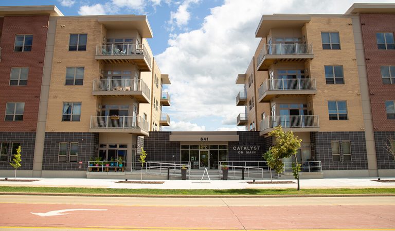 front entrance into apartment building|underground parking entrance under apartment building|ground level apartment front doors|view of apartment pool|pool lounging area with chairs