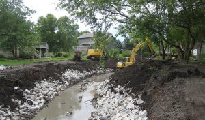 machines dig sides of creek for restoration