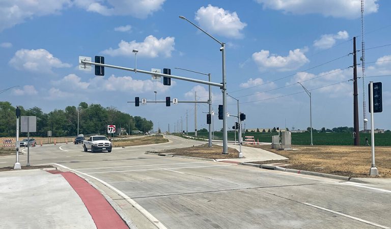 newly constructed roadway intersection|Road traffic transitions into roundabout|Improved traffic flow due to new corridor|Snyder & Associates worker surveying roadway construction|group of people attending a ribbon cutting for new roadway|tower terrace roadway map