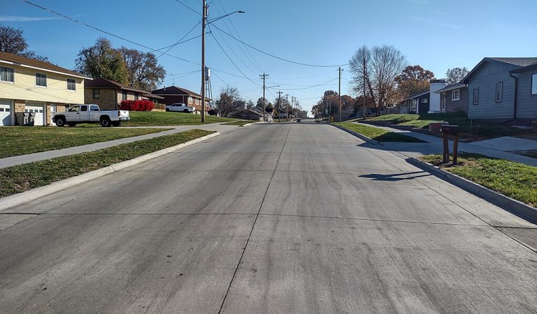 Jasper Street final image||drone photo of detention basin construction|high aerial photo of jasper|rendering of roadway|concrete detention basin along gravel roadway|orange corrugated pipes used in detention basin|aerial photo of jasper construction site|orange dome piping laid in detention basin