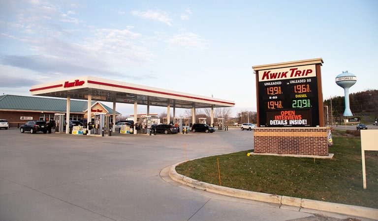fuel prices are displayed on sign as vehicles enter and exit recently complete kwik trip convenience store|cars entering and exiting recently completed gas station|bio-retention basin enhances stormwater mitigation satisfy local requirements|bio-retention basin enhances stormwater mitigation satisfy local requirements for recently completed kwik trip|vehicle parked next to fuel pump in front of a recently complete kwik trip in deforest wisconsin|vehicles refueling at kwik trip convenience store
