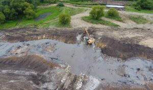 construction machinery creating low water crossing in a stream