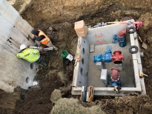 Construction workers drill holes into a SBR effluent flow equalization tank in order to install pump discharge piping that will carry wastewater effluent to a local ethanol plant.