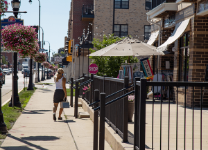 woman walking up to storefront with umbrella out front