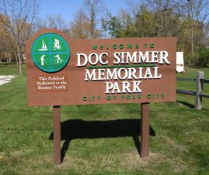 large brown and green welcome sign at the entrance to large park