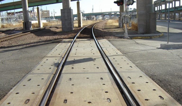 ||train tracks under two large cement overapss