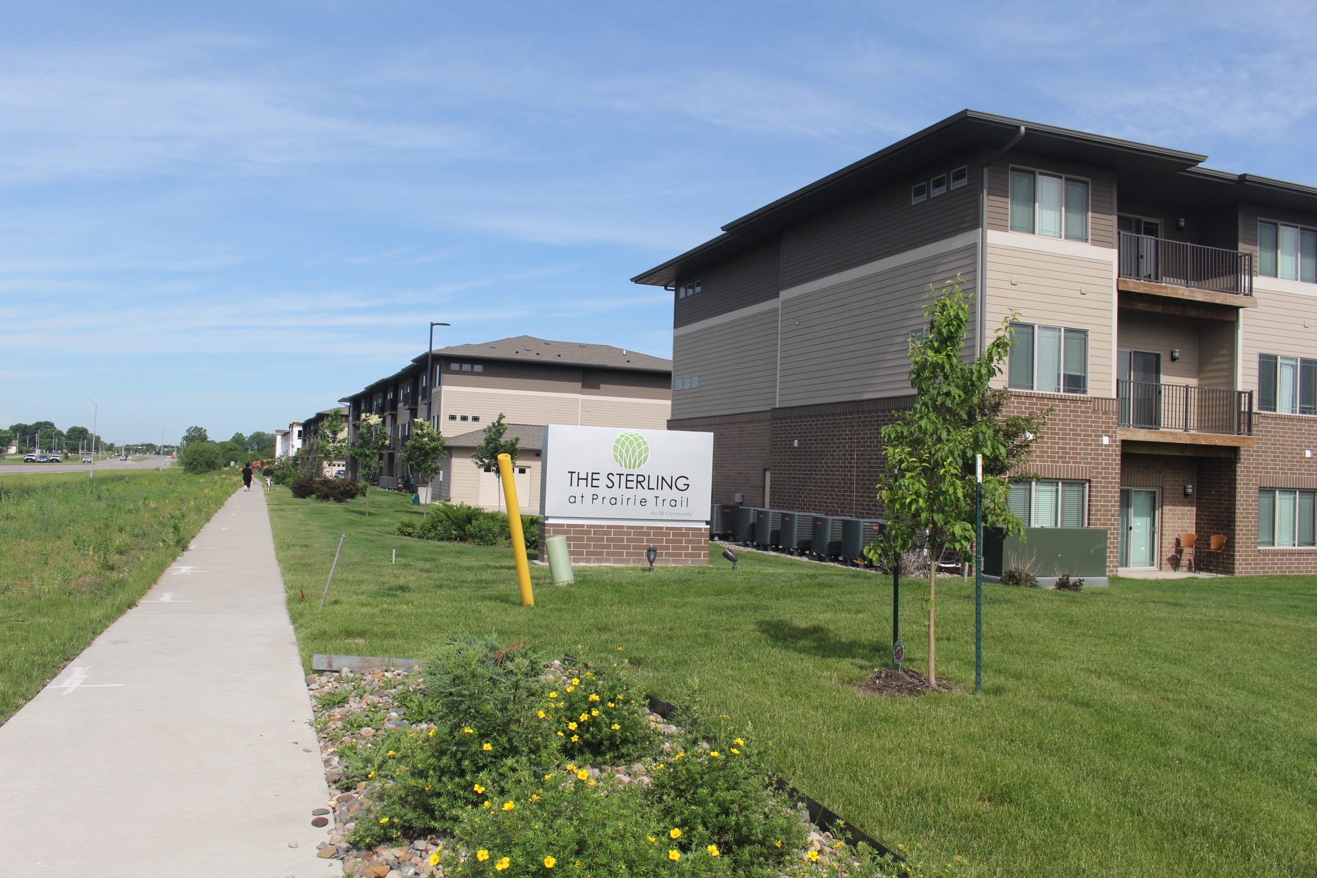 view of new apartments and large sign stating apartment name