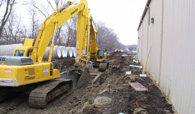 large yellow machine digs hole||||