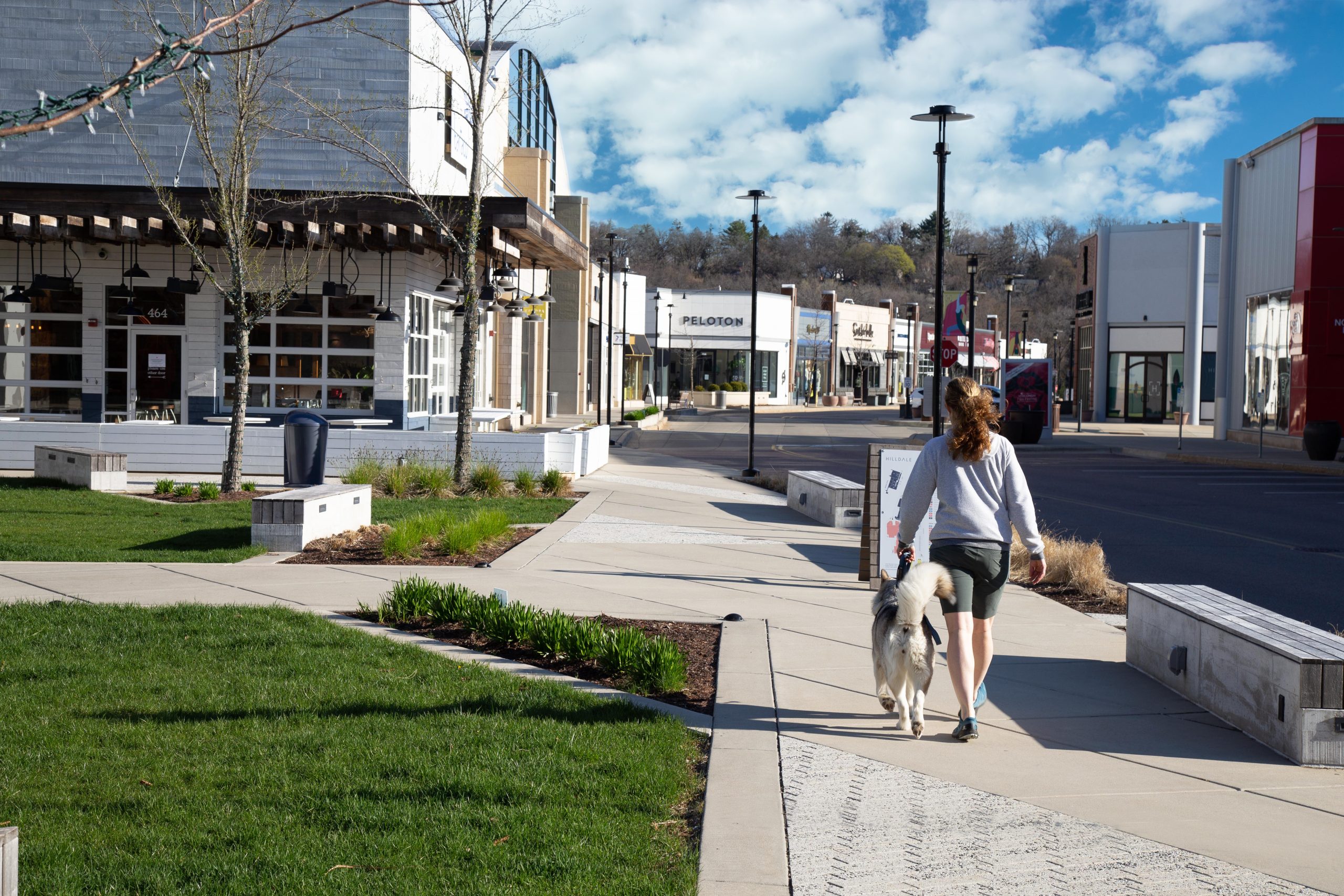 lady walking dog through mall open space