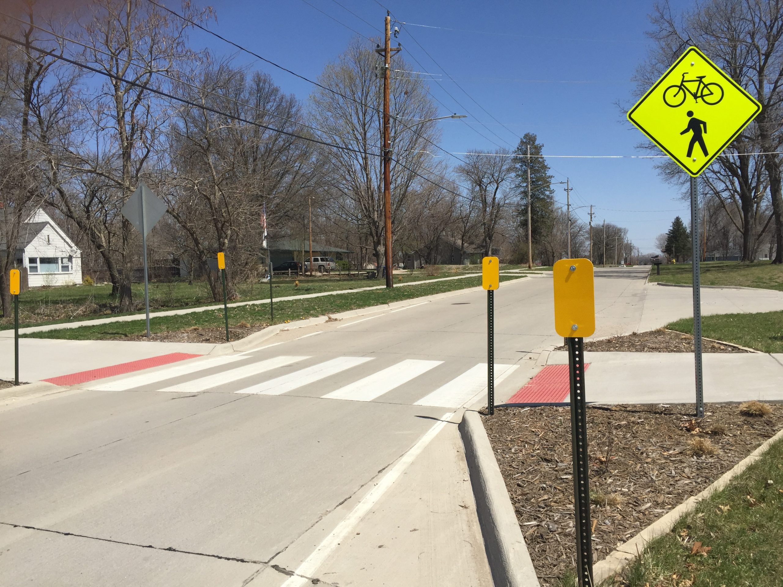 cross walk with neon pedestrian and bike crossing sign