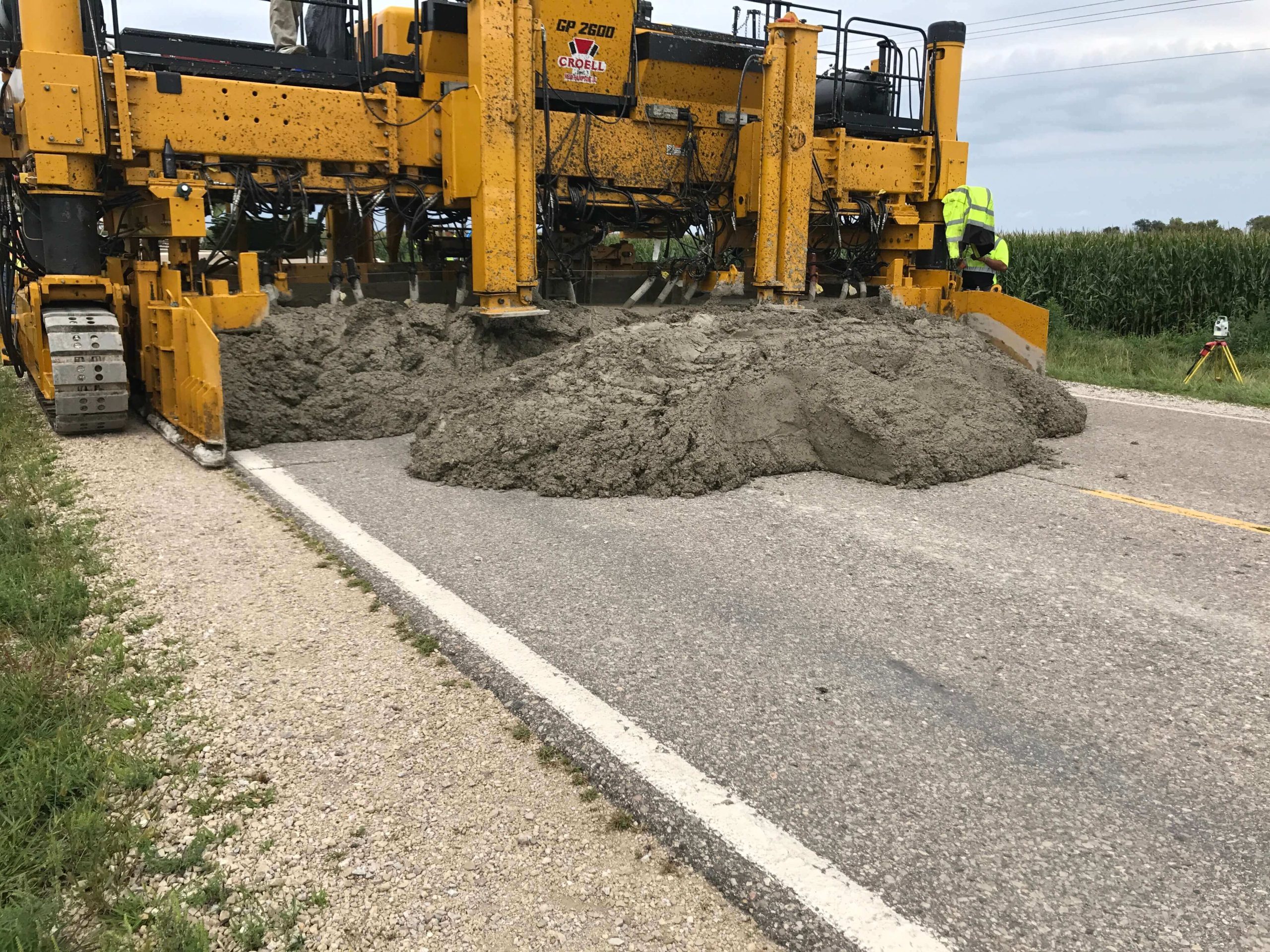machine lays wet concrete over roadway