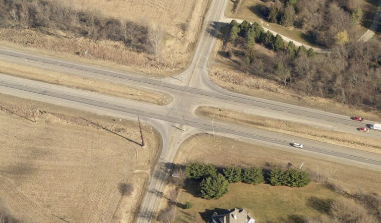 over head shot of project intersection|aerial map with sections highlighted showing project spaces|view down the middle of a road with double yellow stripe|Red truck turning at 4-way intersection