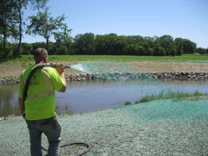 man spraying blue binder on soils