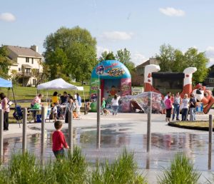 party at splash pad with large inflatables in the background