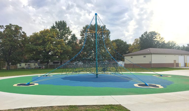 blue and green web climbing structure||new concreate roadway in the fall|concrete skate park bowl|man talking to elderly women over a set of municipal plans