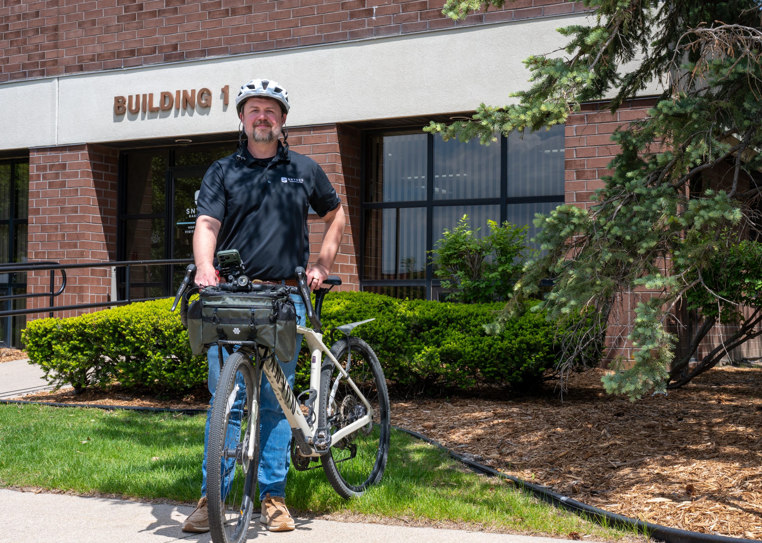 Spencer Wignall smiles for a photo outside of Snyder & Associates after biking to work.