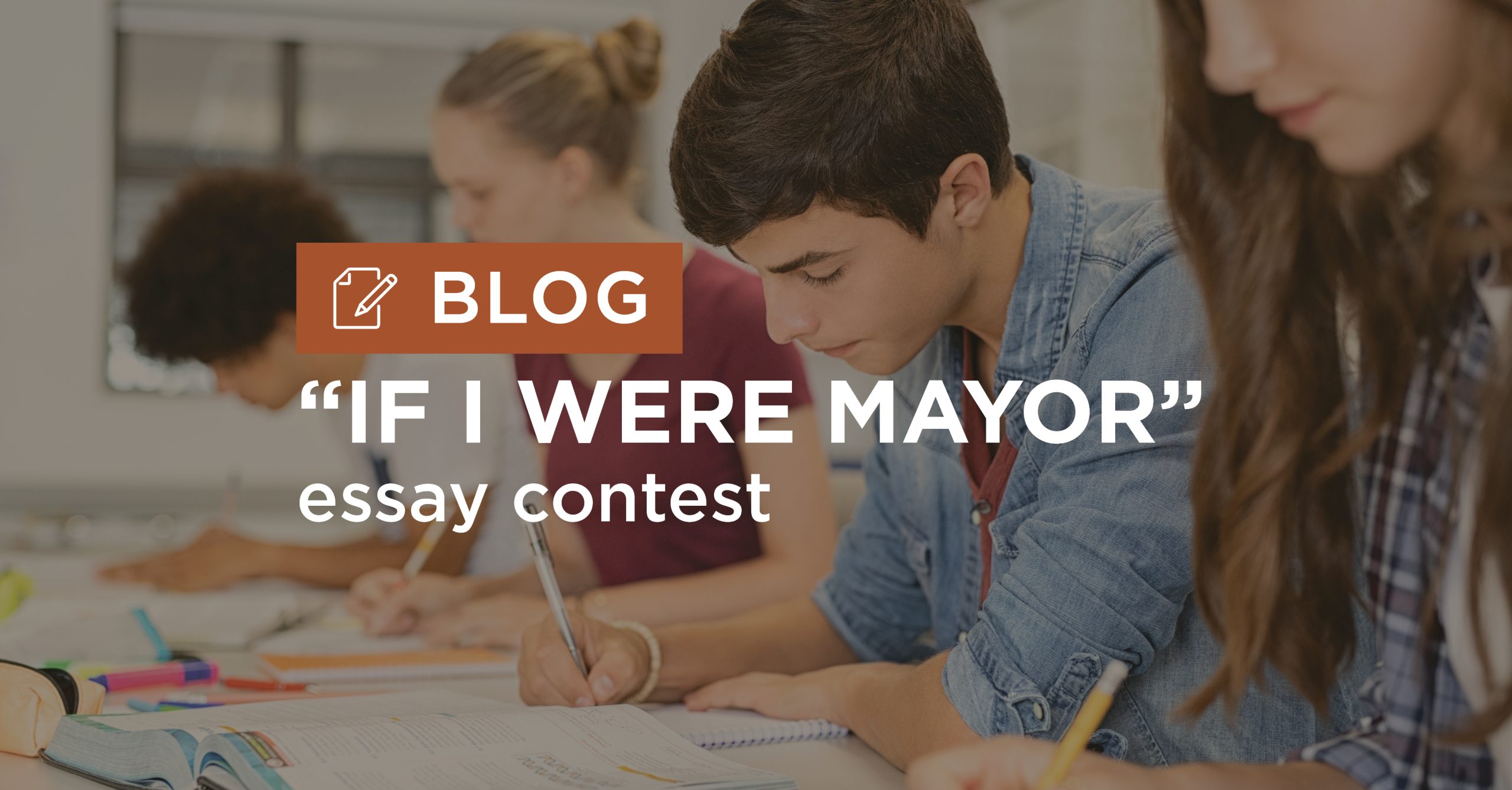 Blog_AnnualIowa7thGradersIfIWereMayorEssayContest_Graphic_Final Students write and study at a desk while a bold blog banner reading 'IF I WERE MAYOR' is overlayed on the image.